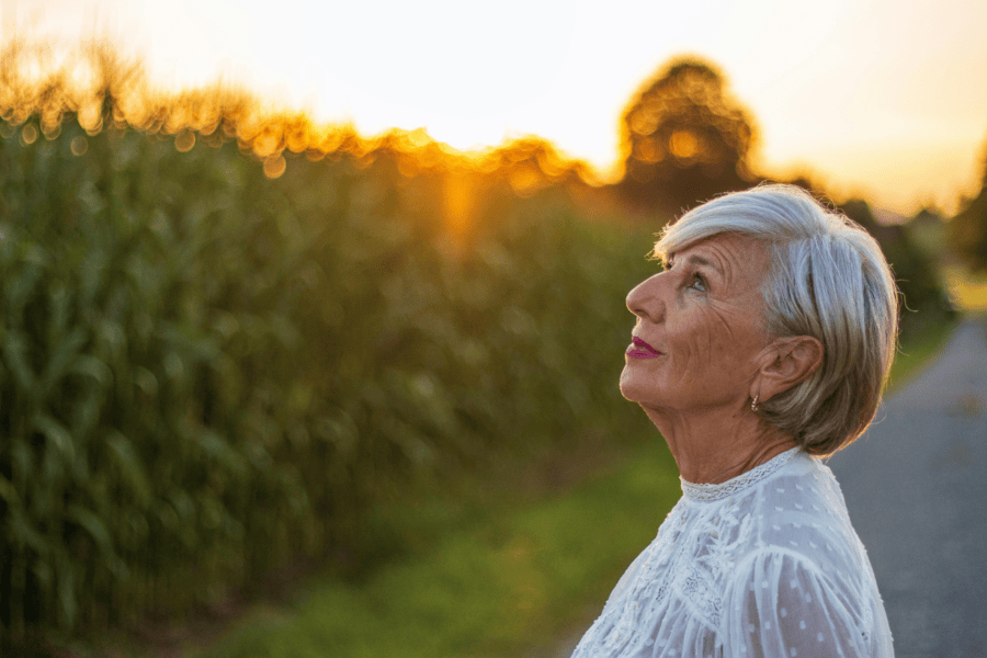 Elderly woman gazing up at sky